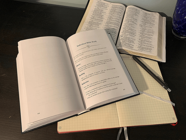 open bible, pen, journal, and A Book of Prayer for Baptists open to Individual Bible Study