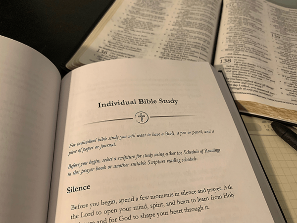 open bible, pen, journal, and A Book of Prayer for Baptists open to Individual Bible Study